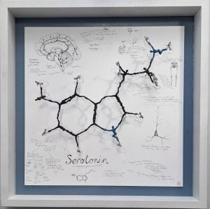 Serotonin sculpture - a framed bronze of the molecule where each atom is represented by a small human figure.