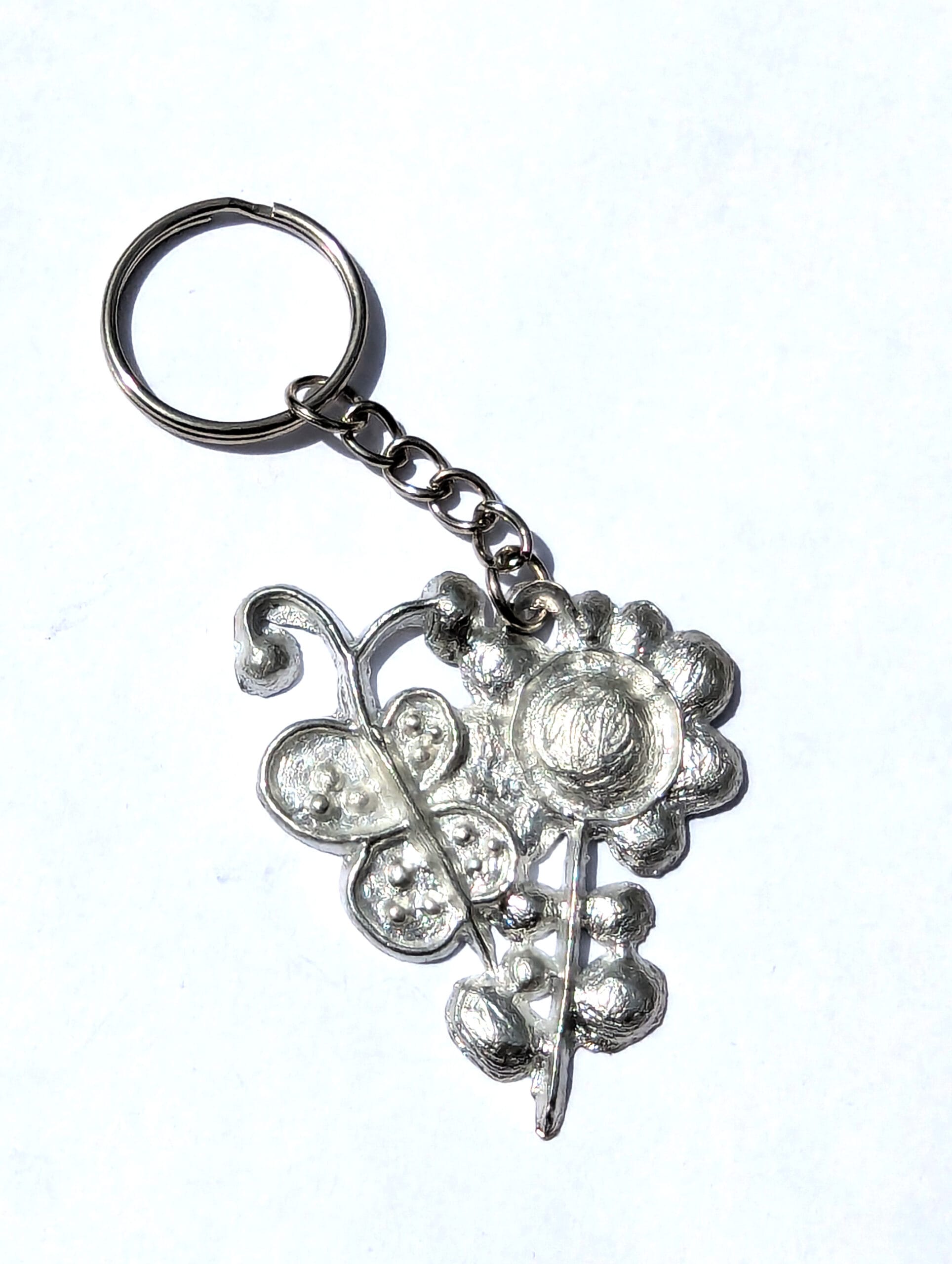 keychain with a pewter pendant of a flower and a butterfly
